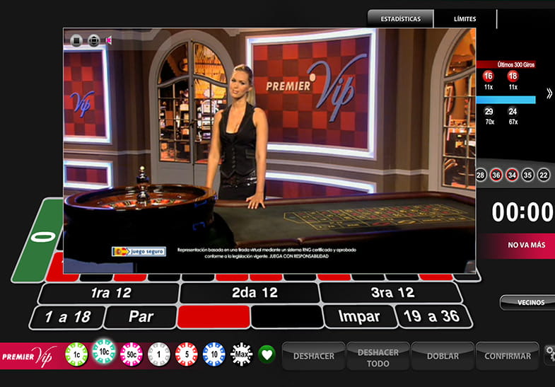 La crupier de la Premier Roulette VIP con los controles del juego, la rueda, y el tapete al fondo.