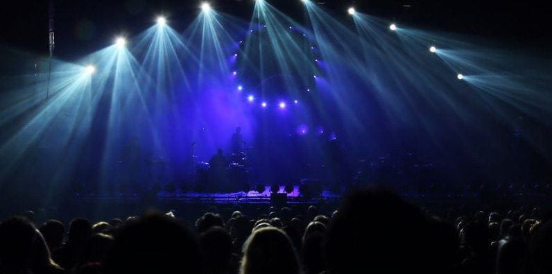 Une scène illuminée de lumières pendant un concert.