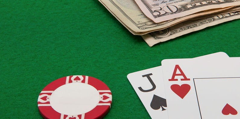 Une table de casino avec de l'argent et deux cartes: un as et un valet