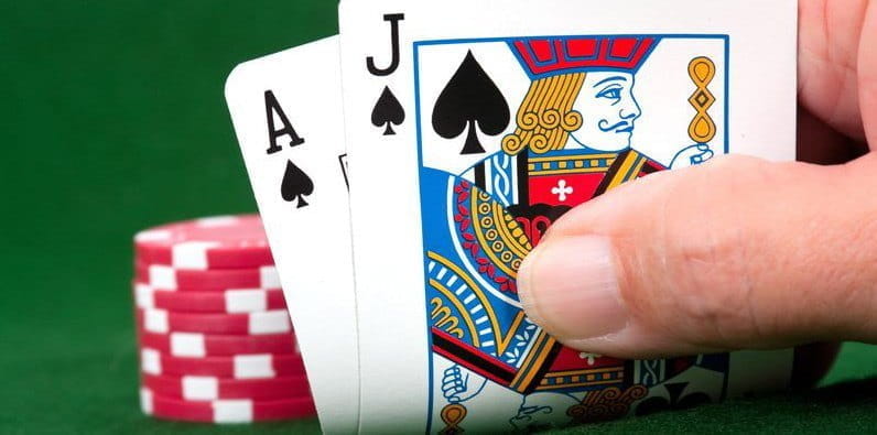 Une main de deux cartes et des jetons de casino