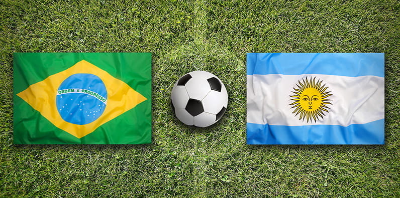 Un ballon de football entre les drapeaux nationaux du Brésil et de l'Argentine