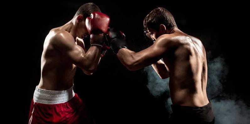 Un boxeur se défend d'une attaque de son adversaire