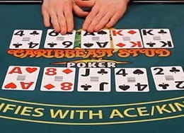 Table de casino sur laquelle les cartes de poker en direct et les mains du croupier sont visibles.
