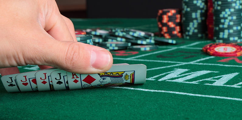 Jugador mostrando sus cartas en una mesa de póker