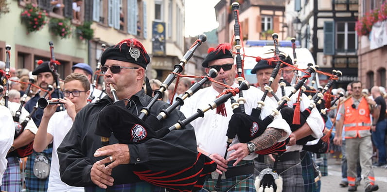 Groupe d'hommes dans la rue vêtus de vêtements traditionnels écossais et jouant de la cornemuse